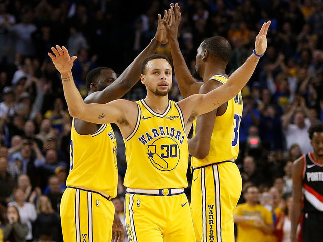 OAKLAND, CA - DECEMBER 27: Kevin Durant #35, Stephen Curry #30 and Draymond Green #23 of the Golden State Warriors celebrate after a basket against the Portland Trail Blazers at ORACLE Arena on December 27, 2018 in Oakland, California.