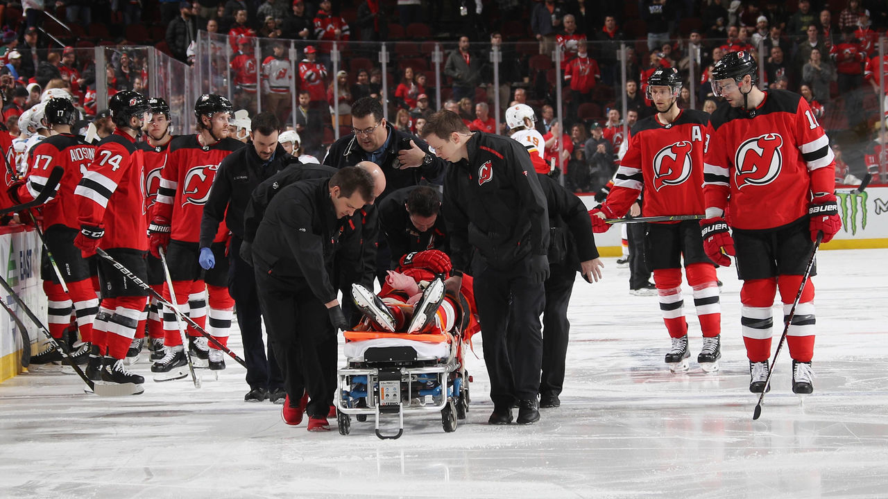 NEWARK, NEW JERSEY - FEBRUARY 27: Mirco Mueller #25 of the New Jersey Devils is taken off the ice after a third period injury against the Calgary Flames at the Prudential Center on February 27, 2019 in Newark, New Jersey. The Flames defeated the devils 2-1.