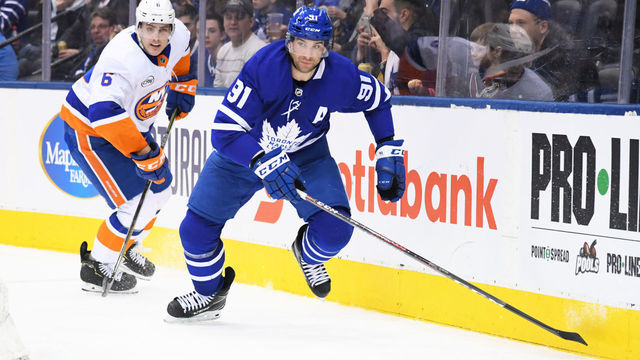 TORONTO, ON - DECEMBER 29: Toronto Maple Leafs center John Tavares (91) battles with New York Islanders defenseman Ryan Pulock (6) during the third period in a game between the New York Islanders and the Toronto Maple Leafs at Scotiabank Arena in Toronto, Ontario Canada. The New York Islanders won 4-0.