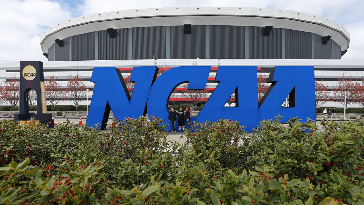 ATLANTA, GA - APRIL 05: Fans stand next to a giant NCAA logo outside of the stadium on the practice day prior to the NCAA Men's Final Four at the Georgia Dome on April 5, 2013 in Atlanta, Georgia.