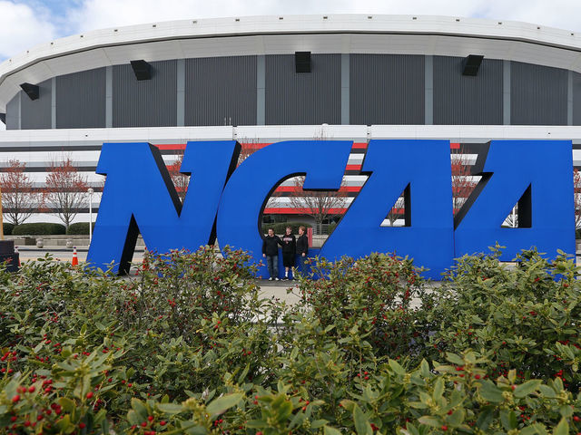 ATLANTA, GA - APRIL 05: Fans stand next to a giant NCAA logo outside of the stadium on the practice day prior to the NCAA Men's Final Four at the Georgia Dome on April 5, 2013 in Atlanta, Georgia.