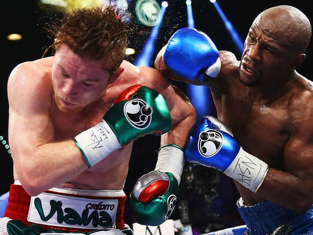 LAS VEGAS, NV - SEPTEMBER 14: (L-R) Floyd Mayweather Jr. throws a right to Canelo Alvarez during their WBC/WBA 154-pound title fight at the MGM Grand Garden Arena on September 14, 2013 in Las Vegas, Nevada.
