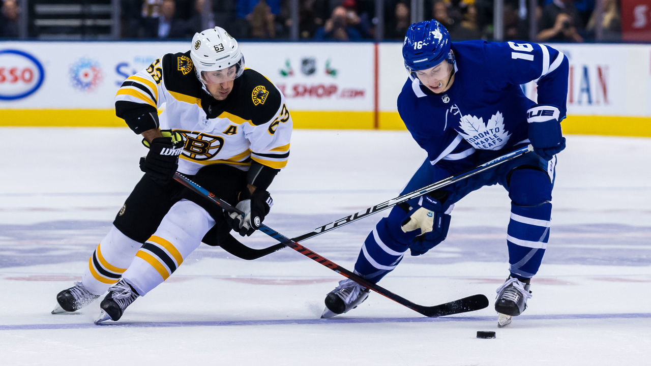 TORONTO, ON - NOVEMBER 26: Mitchell Marner #16 of the Toronto Maple Leafs and Brad Marchand #63 of the Boston Bruins battle for the puck during the first period at the Scotiabank Arena on November 26, 2018 in Toronto, Ontario, Canada.