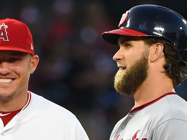 ANAHEIM, CA - JULY 18: Bryce Harper #34 of the Washington Nationals talks with Kole Calhoun #56 and Mike Trout #27 of the Los Angeles Angels as a play if being reviewed in the game at Angel Stadium of Anaheim on July 18, 2017 in Anaheim, California.