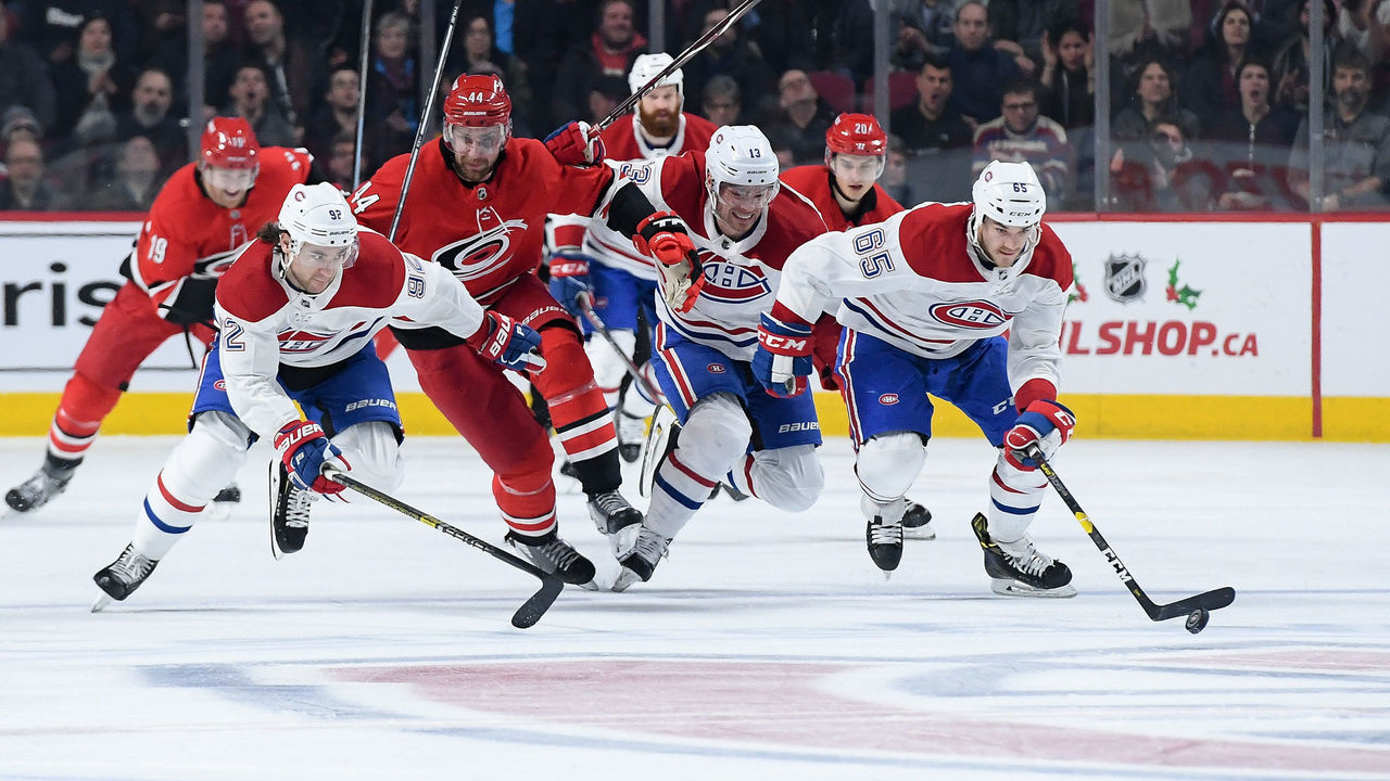 MONTREAL, QC - DECEMBER 13: Andrew Shaw #65 of the Montreal Canadiens skates with the puck against Calvin de Haan #44 of the Carolina Hurricanes in the NHL game at the Bell Centre on December 13, 2018 in Montreal, Quebec, Canada.