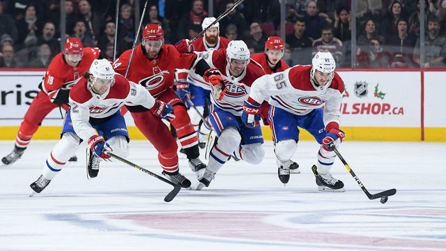 MONTREAL, QC - DECEMBER 13: Andrew Shaw #65 of the Montreal Canadiens skates with the puck against Calvin de Haan #44 of the Carolina Hurricanes in the NHL game at the Bell Centre on December 13, 2018 in Montreal, Quebec, Canada.