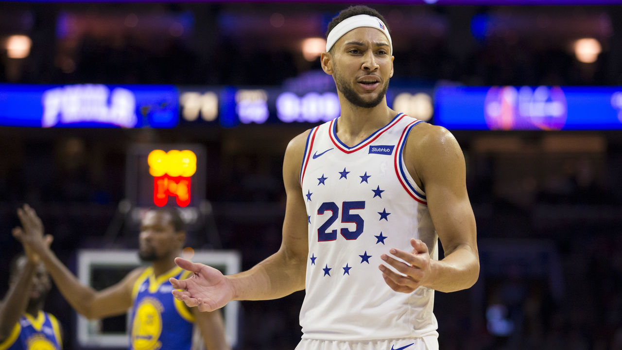 PHILADELPHIA, PA - MARCH 02: Ben Simmons #25 of the Philadelphia 76ers reacts in front of Draymond Green #23 and Kevin Durant #35 of the Golden State Warriors at the Wells Fargo Center on March 2, 2019 in Philadelphia, Pennsylvania. The Warriors defeated the 76ers 120-117.