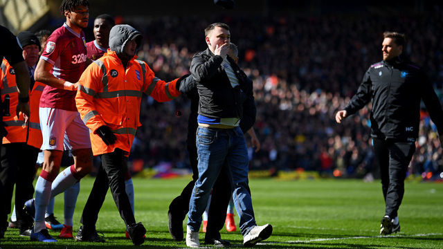 BIRMINGHAM, ENGLAND - MARCH 10: A fan is escorted off the pitch after striking Jack Grealish of Aston Villa during the Sky Bet Championship match between Birmingham City and Aston Villa at St Andrew's Trillion Trophy Stadium on March 10, 2019 in Birmingham, England.