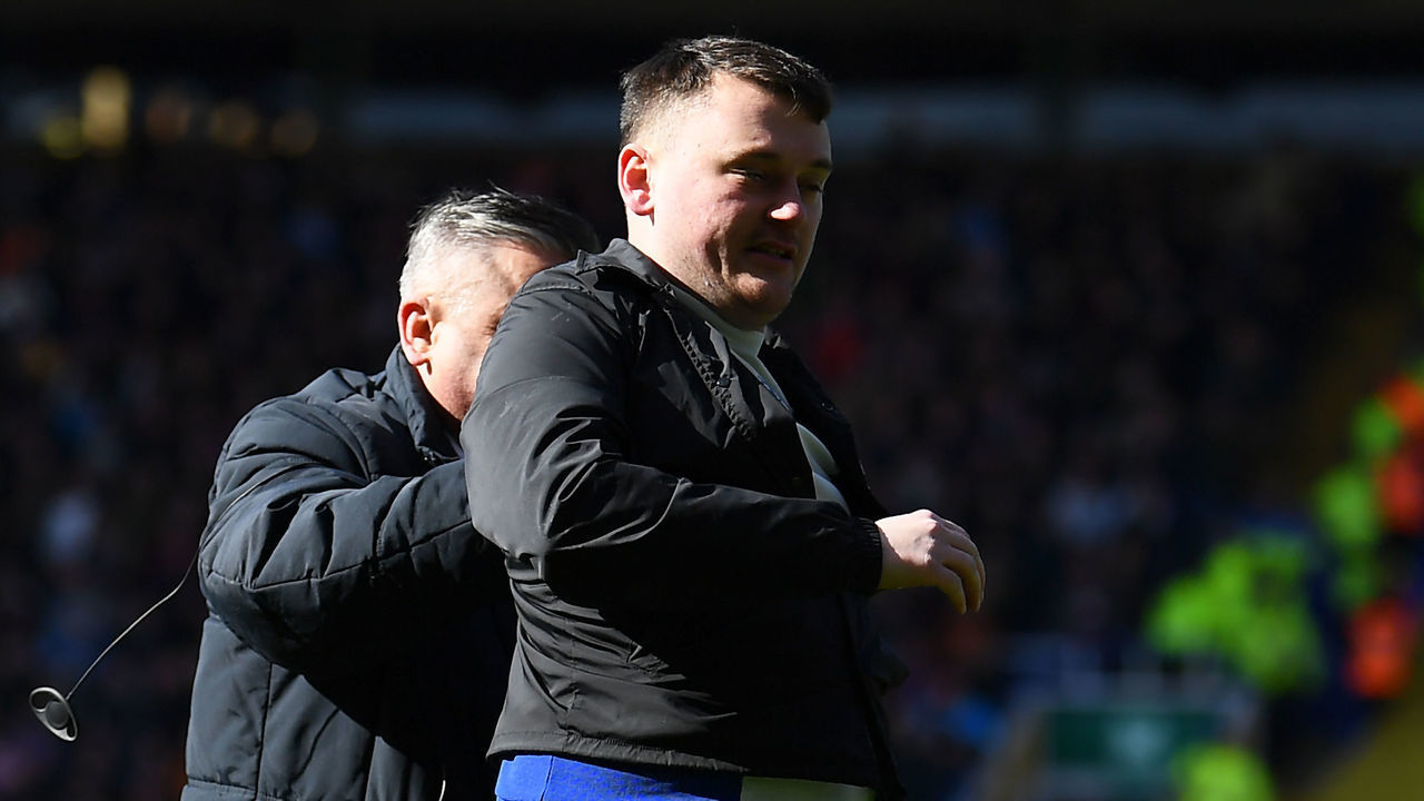 BIRMINGHAM, ENGLAND - MARCH 10: A fan is escorted off the pitch after striking Jack Grealish of Aston Villa during the Sky Bet Championship match between Birmingham City and Aston Villa at St Andrew's Trillion Trophy Stadium on March 10, 2019 in Birmingham, England.