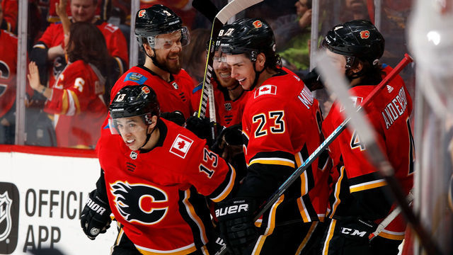 CALGARY, AB - MARCH 12: Johnny Gaudreau #13 of the Calgary Flames is congratulated by Sean Monahan #23 and Rasmus Andersson #4 of the Calgary Flames and teammates after scoring his third goal against the New Jersey Devils during an NHL game on March 12, 2019 at the Scotiabank Saddledome in Calgary, Alberta, Canada.