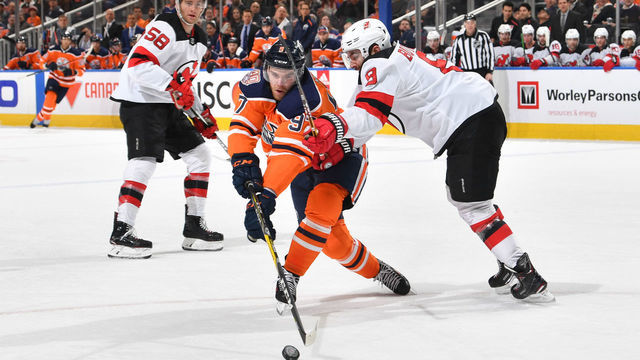 EDMONTON, AB - MARCH 13: Connor McDavid #97 of the Edmonton Oilers battles for the puck against Will Butcher #8 of the New Jersey Devils on March 13, 2019 at Rogers Place in Edmonton, Alberta, Canada.