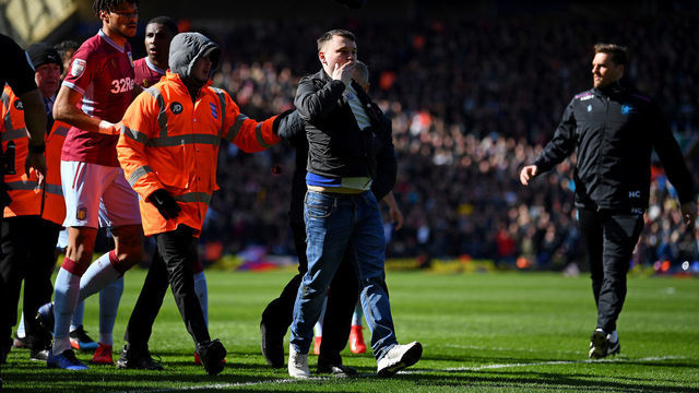 BIRMINGHAM, ENGLAND - MARCH 10: A fan is escorted off the pitch after striking Jack Grealish of Aston Villa during the Sky Bet Championship match between Birmingham City and Aston Villa at St Andrew's Trillion Trophy Stadium on March 10, 2019 in Birmingham, England.
