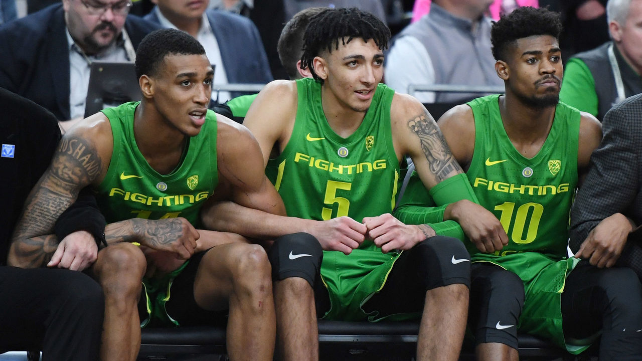 LAS VEGAS, NEVADA - MARCH 15: Kenny Wooten #14, Miles Norris #5 and Victor Bailey Jr. #10 of the Oregon Ducks lock arms on the bench during overtime of their semifinal game of the Pac-12 basketball tournament against the Arizona State Sun Devils at T-Mobile Arena on March 15, 2019 in Las Vegas, Nevada. The Ducks defeated the Sun Devils 79-75 in overtime.
