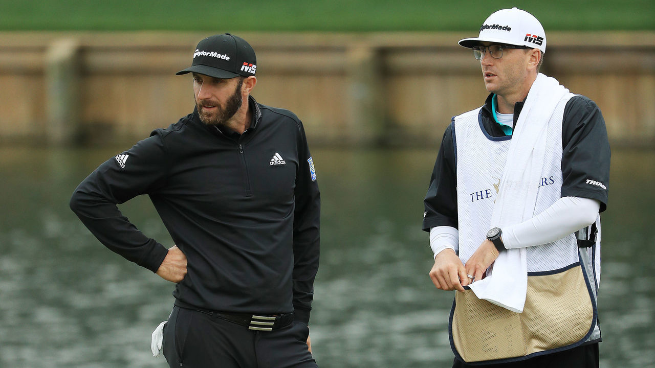 PONTE VEDRA BEACH, FLORIDA - MARCH 17: Dustin Johnson of the United States and his caddie and brother Austin Johnson look on from the 18th green during the final round of The PLAYERS Championship on The Stadium Course at TPC Sawgrass on March 17, 2019 in Ponte Vedra Beach, Florida.