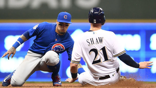 MILWAUKEE, WI - JUNE 12: Travis Shaw #21 of the Milwaukee Brewers is tagged out at second base by Javier Baez #9 of the Chicago Cubs during the fifth inning of a game at Miller Park on June 12, 2018 in Milwaukee, Wisconsin.