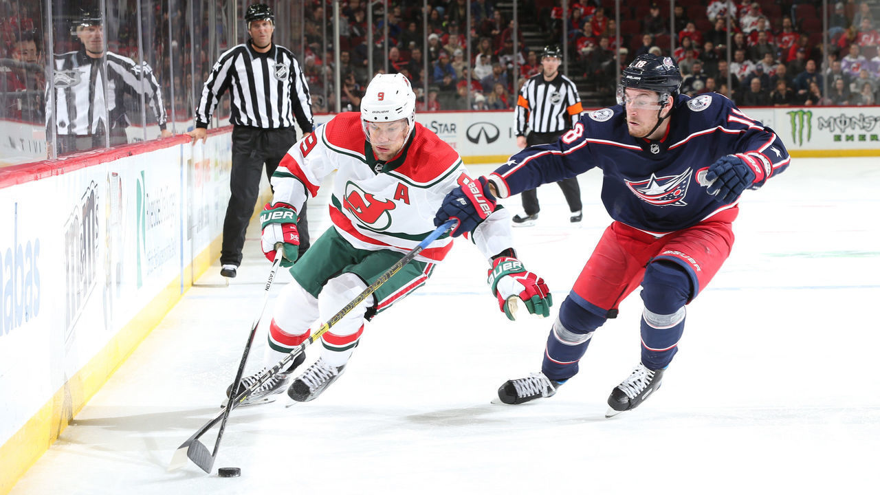 NEWARK, NJ - DECEMBER 23: Taylor Hall #9 of the New Jersey Devils skates with the puck against Pierre-Luc Dubois of the Columbus Blue Jackets at Prudential Center on December 23, 2018 in Newark, New Jersey.