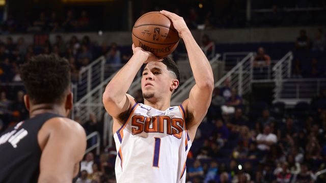 PHOENIX, AZ - MARCH 27: Devin Booker #1 of the Phoenix Suns shoots three point basket against the Washington Wizards on March 27, 2019 at Talking Stick Resort Arena in Phoenix, Arizona. Mandatory Copyright Notice: Copyright 2019 NBAE