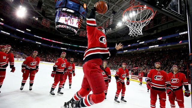 RALEIGH, NC - MARCH 23: Trevor van Riemsdyk #57 of the Carolina Hurricanes dunks a basketball during the Storm Surge following an NHL game against the Minnesota Wild on March 23, 2019 at PNC Arena in Raleigh, North Carolina.