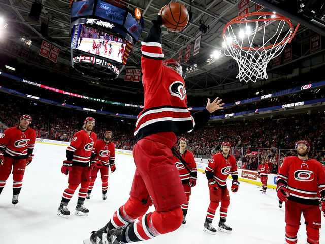RALEIGH, NC - MARCH 23: Trevor van Riemsdyk #57 of the Carolina Hurricanes dunks a basketball during the Storm Surge following an NHL game against the Minnesota Wild on March 23, 2019 at PNC Arena in Raleigh, North Carolina.