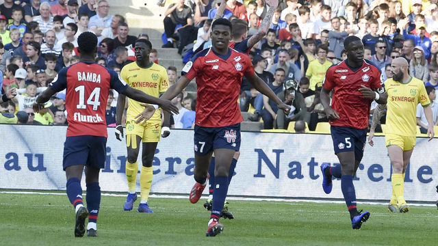 Lille's French forward Jonathan Bamba (C) celebrates after scoring a goal with Lille's Portuguese forward Rafael Leao (R) during the French L1 football match between FC Nantes and Lille OSC (LOSC) at the La Beaujoire stadium in Nantes, western France on March 31, 2019.