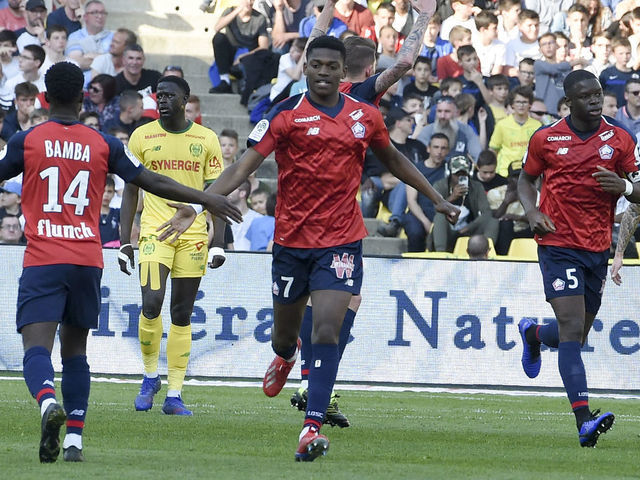 Lille's French forward Jonathan Bamba (C) celebrates after scoring a goal with Lille's Portuguese forward Rafael Leao (R) during the French L1 football match between FC Nantes and Lille OSC (LOSC) at the La Beaujoire stadium in Nantes, western France on March 31, 2019.