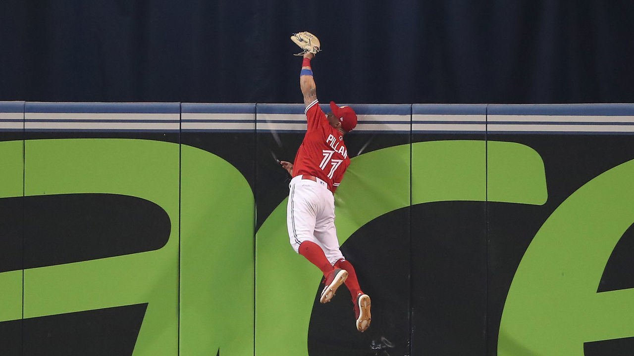 TORONTO, ON - JULY 1: Kevin Pillar #11 of the Toronto Blue Jays climbs the wall and catches a fly ball hit by Nicholas Castellanos #9 of the Detroit Tigers in the ninth inning during MLB game action at Rogers Centre on July 1, 2018 in Toronto, Canada.