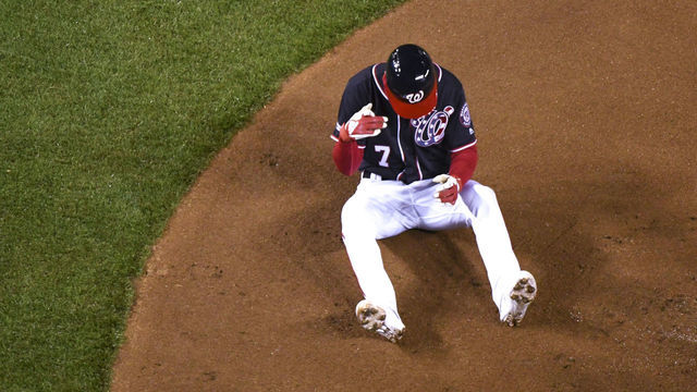 WASHINGTON, DC - APRIL 2: Washington Nationals shortstop Trea Turner (7) sits on the ground after squaring to bunt and taking a pitch off of his index finger during the game between the Philadelphia Phillies and the Washington Nationals on April 2, 2019, at Nationals Park, in Washington D.C. Turner was forced to leave the game in the first inning with the injury.