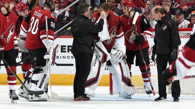 GLENDALE, AZ - APRIL 02: Goalie Darcy Kuemper #35 of the Arizona Coyotes is attended to by team trainers and teammate Clayton Keller #9 after the stick blade of Trevor Lewis #22 of the Los Angeles Kings got caught in his face mask during a third period goal by Lewis at Gila River Arena on April 2, 2019 in Glendale, Arizona.