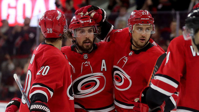 RALEIGH, NC - APRIL 4: Sebastian Aho #20 and Nino Niederreiter #21 celebrate a goal by teammate Justin Faulk, center, of the Carolina Hurricanes against the New Jersey Devils during an NHL game at PNC Arena on April 4, 2019, in Raleigh, North Carolina.