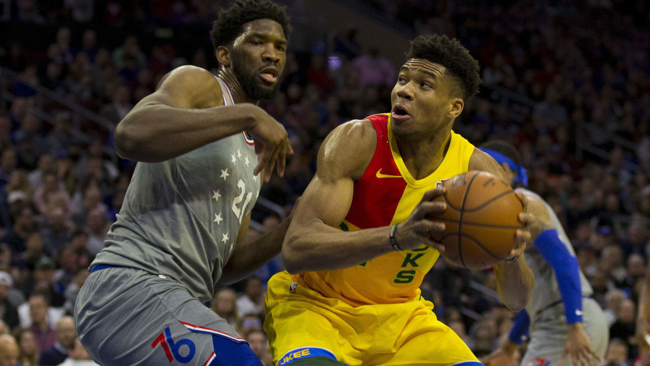 PHILADELPHIA, PA - APRIL 04: Giannis Antetokounmpo #34 of the Milwaukee Bucks controls the ball against Joel Embiid #21 of the Philadelphia 76ers in the first quarter at the Wells Fargo Center on April 4, 2019 in Philadelphia, Pennsylvania.
