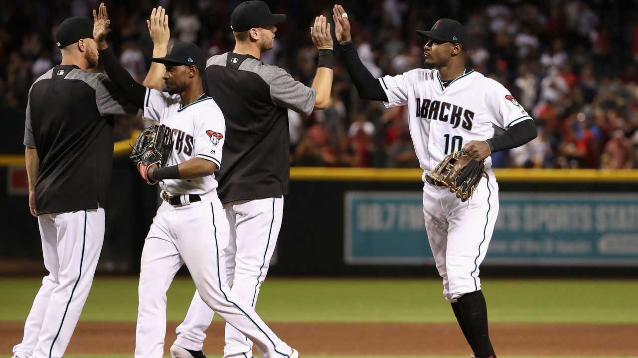 PHOENIX, ARIZONA - APRIL 05: Jarrod Dyson #1 and Adam Jones #10 of the Arizona Diamondbacks high five teammates after defeating the Boston Red Sox 15-8 in the MLB game at Chase Field on April 05, 2019 in Phoenix, Arizona.