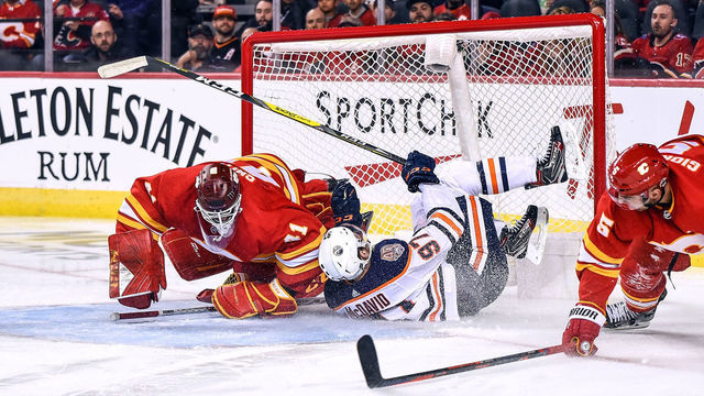 CALGARY, AB - APRIL 06: Edmonton Oilers Center Connor McDavid (97) crashes into Calgary Flames Goalie Mike Smith (41) and the net during the second period of an NHL game where the Calgary Flames hosted the Edmonton Oilers on April 6, 2019, at the Scotiabank Saddledome in Calgary, AB.