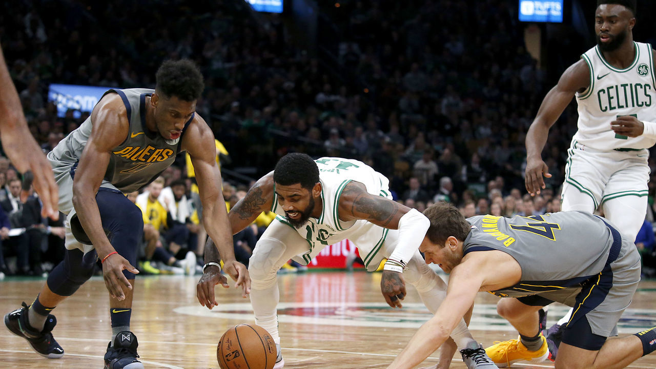 BOSTON - MARCH 29: Boston Celtics' Kyrie Irving, center, battles for a loose ball with Indiana Pacers' Thaddeus Young, left, and Bojan Bogdanovic during the fourth quarter. The Boston Celtics host the Indiana Pacers in a regular season NBA basketball game at TD Garden in Boston on March 29, 2019.
