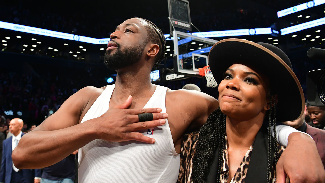 NEW YORK, NEW YORK - APRIL 10: Dwyane Wade #3 of the Miami Heat thanks the fans with his wife Gabrielle Union after the game against the Brooklyn Nets at Barclays Center on April 10, 2019 in the Brooklyn borough of New York City. This was Wade's last NBA game before retirement.