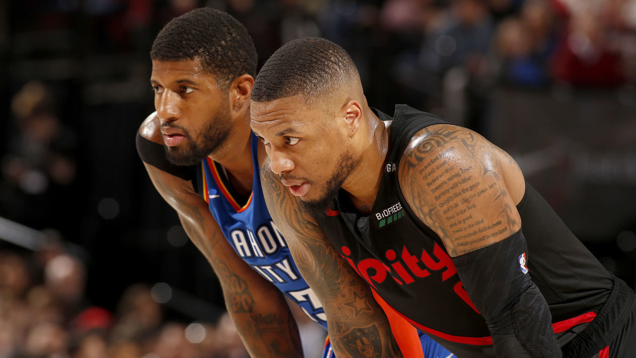 PORTLAND, OR - MARCH 7: Paul George #13 of the Oklahoma City Thunder and Damian Lillard #0 of the Portland Trail Blazers look on during the game on March 7, 2019 at the Moda Center Arena in Portland, Oregon. Mandatory Copyright Notice: Copyright 2019 NBAE