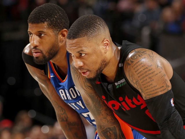 PORTLAND, OR - MARCH 7: Paul George #13 of the Oklahoma City Thunder and Damian Lillard #0 of the Portland Trail Blazers look on during the game on March 7, 2019 at the Moda Center Arena in Portland, Oregon. Mandatory Copyright Notice: Copyright 2019 NBAE