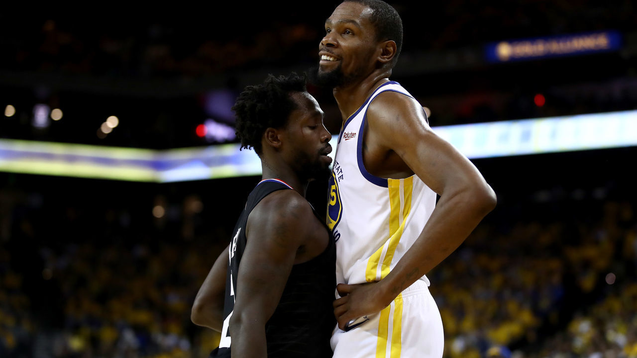 OAKLAND, CALIFORNIA - APRIL 13: Patrick Beverley #21 of the LA Clippers plays tight defense on Kevin Durant #35 of the Golden State Warriors during Game One of the first round of the 2019 NBA Western Conference Playoffs at ORACLE Arena on April 13, 2019 in Oakland, California. Both players were ejected later in the game.