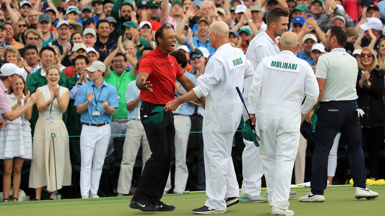 AUGUSTA, GEORGIA - APRIL 14: Tiger Woods (L) of the United States celebrates with caddie Joe LaCava (R) on the 18th green after winning during the final round of the Masters at Augusta National Golf Club on April 14, 2019 in Augusta, Georgia.