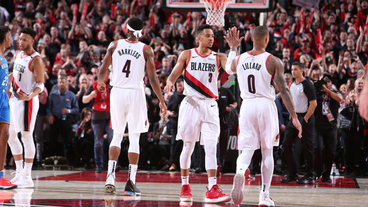 PORTLAND, OR - APRIL 14: CJ McCollum #3 and Damian Lillard #0 of the Portland Trail Blazers high five against the Oklahoma City Thunder during Game One of Round One of the 2019 NBA Playoffs on April 14, 2019 at the Moda Center Arena in Portland, Oregon. Mandatory Copyright Notice: Copyright 2019 NBAE