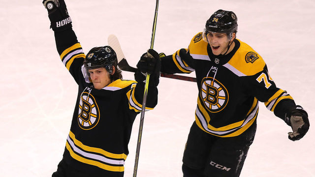 BOSTON - DECEMBER 21: Boston Bruins' Torey Krug, left, celebrates his third period goal with teammate Jake DeBrusk. The Boston Bruins host the Winnipeg Jets in a regular season NHL hockey game at TD Garden in Boston on Dec. 21, 2017.
