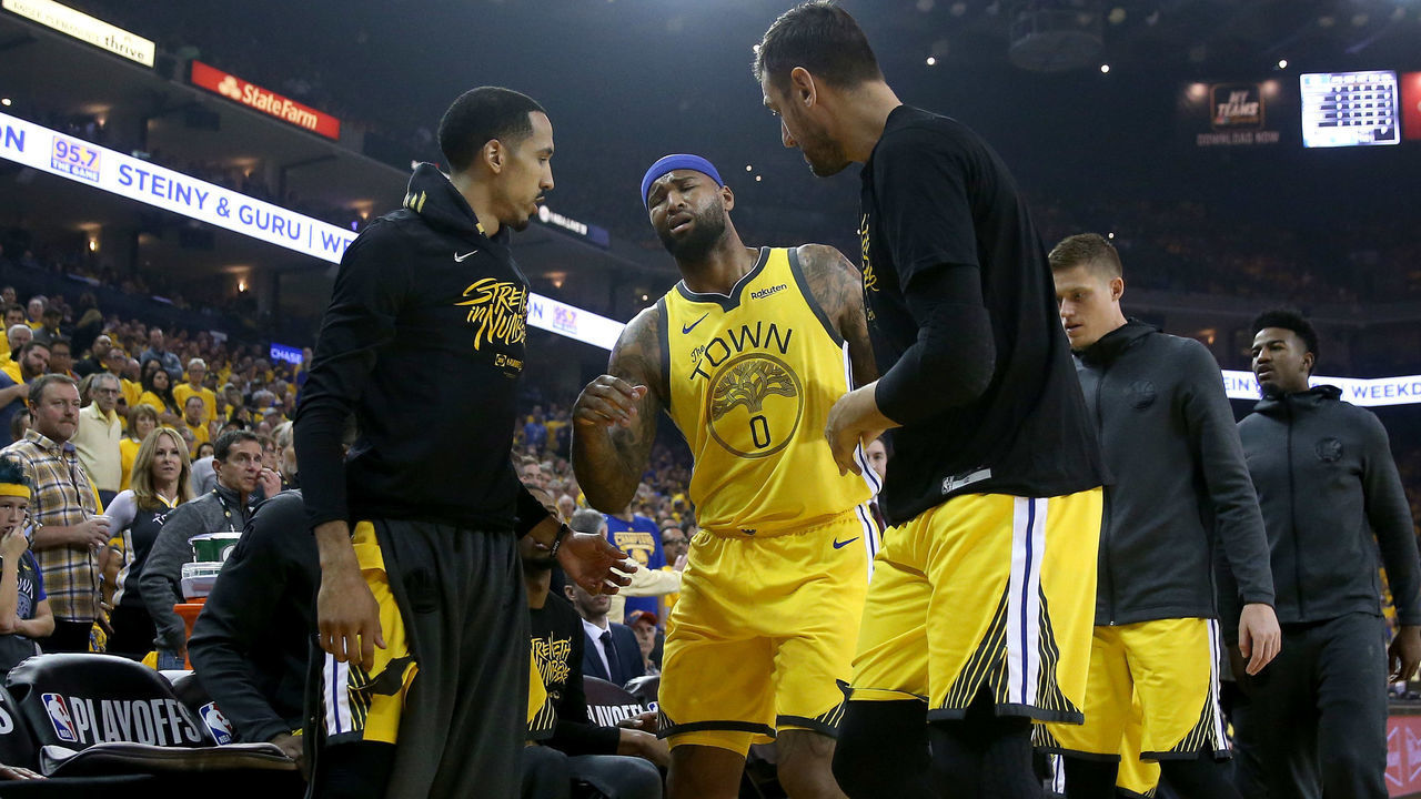 OAKLAND, CALIFORNIA - APRIL 15: DeMarcus Cousins #0 of the Golden State Warriors is helped off the court after injuring himself against the LA Clippers during Game Two of the first round of the 2019 NBA Western Conference Playoffs at ORACLE Arena on April 15, 2019 in Oakland, California.