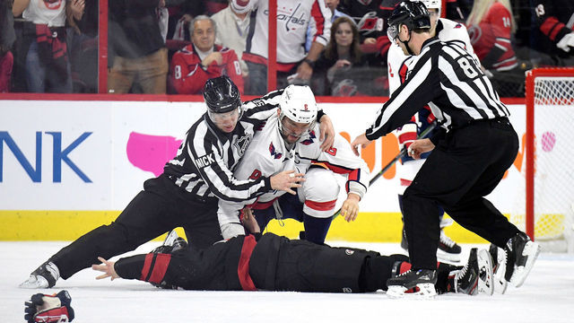 RALEIGH, NORTH CAROLINA - APRIL 15: Linesman Scott Cherrey #50 pulls Alex Ovechkin #8 of the Washington Capitals off of Andrei Svechnikov #37 of the Carolina Hurricanes during the first period in Game Three of the Eastern Conference First Round during the 2019 NHL Stanley Cup Playoffs at PNC Arena on April 15, 2019 in Raleigh, North Carolina.