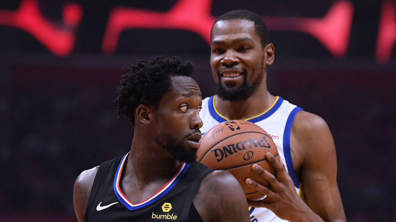 LOS ANGELES, CALIFORNIA - APRIL 18: Patrick Beverley #21 of the LA Clippers looks back at a smiling Kevin Durant #35 of the Golden State Warriors during Game Two of Round One of the 2019 NBA Playoffs at Staples Center on April 18, 2019 in Los Angeles, California.