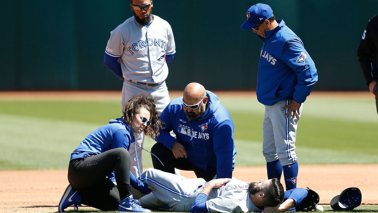 OAKLAND, CA - APRIL 20: Starting pitcher Matt Shoemaker #34 of the Toronto Blue Jays receives treatment on his leg after a collision while getting the out of Matt Chapman #26 of the Oakland Athletics in the bottom of the third inning at Oakland-Alameda County Coliseum on April 20, 2019 in Oakland, California.