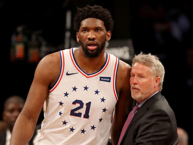 NEW YORK, NEW YORK - APRIL 20: Head coach Brett Brown of the Philadelphia 76ers holds back his player Joel Embiid #21 after a scuffle between Brooklyn Nets and Philadelphia 76ers players in the third quarter at Barclays Center on April 20, 2019 in the Brooklyn borough of New York City.The Philadelphia 76ers defeated the Brooklyn Nets 112-108.