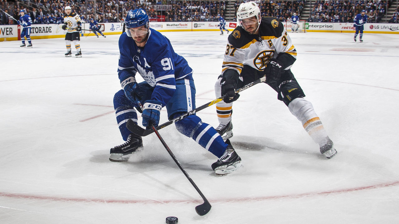TORONTO, ON - APRIL 15: John Tavares #91 of the Toronto Maple Leafs battles for the puck against Patrice Bergeron #37 of the Boston Bruins during the first period in Game Three of the Eastern Conference First Round during the 2019 NHL Stanley Cup Playoffs at the Scotiabank Arena on April 15, 2019 in Toronto, Ontario, Canada.