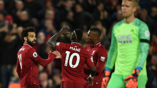 Liverpool's Egyptian midfielder Mohamed Salah (L) celebrates with teammates after he scores the team's third goal during the English Premier League football match between Liverpool and Huddersfield at Anfield in Liverpool, north west England on April 26, 2019.