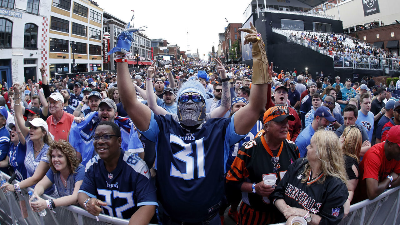 NASHVILLE, TN - APRIL 25: A Tennessee Titans fan stands at the end of Broadway Street as a mass of fans assemble prior to the first round of the NFL Draft on April 25, 2019 in Nashville, Tennessee.