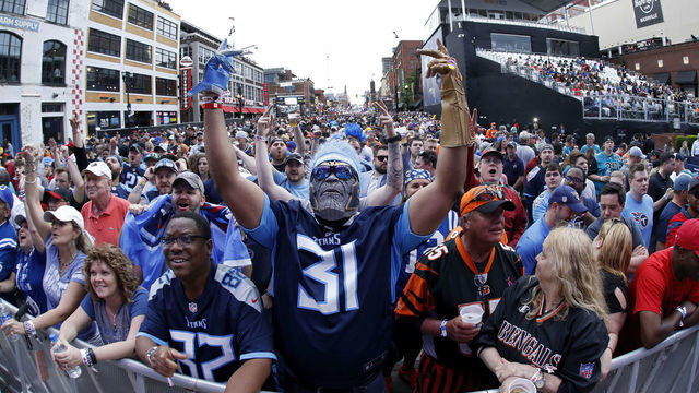 NASHVILLE, TN - APRIL 25: A Tennessee Titans fan stands at the end of Broadway Street as a mass of fans assemble prior to the first round of the NFL Draft on April 25, 2019 in Nashville, Tennessee.