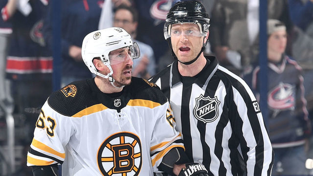 COLUMBUS, OH - APRIL 30: Linesmen Devin Berg #87 escorts Brad Marchand #63 of the Boston Bruins to the penalty box following a minor high-sticking penalty during the second period in Game Three of the Eastern Conference Second Round against the Columbus Blue Jackets during the 2019 NHL Stanley Cup Playoffs on April 30, 2019 at Nationwide Arena in Columbus, Ohio.